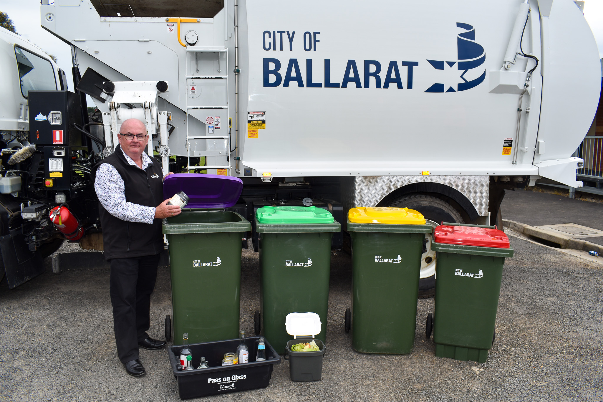 Mayor Des Hudson with four bins in front of a rubbish truck