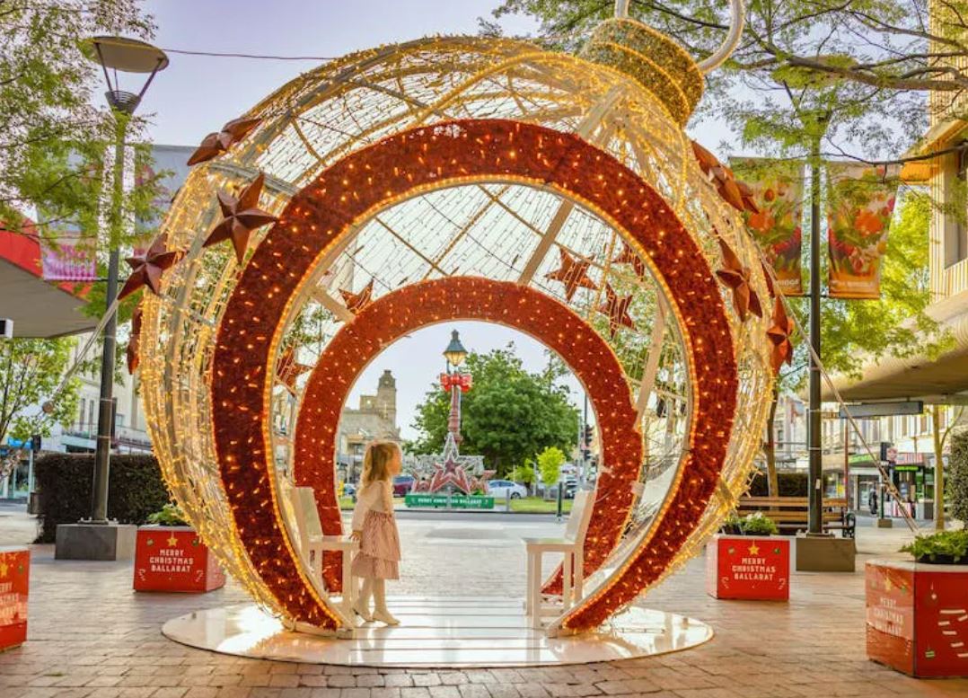 A giant red and gold Christmas bauble display, with a small doorway for people to walk through. to walk 