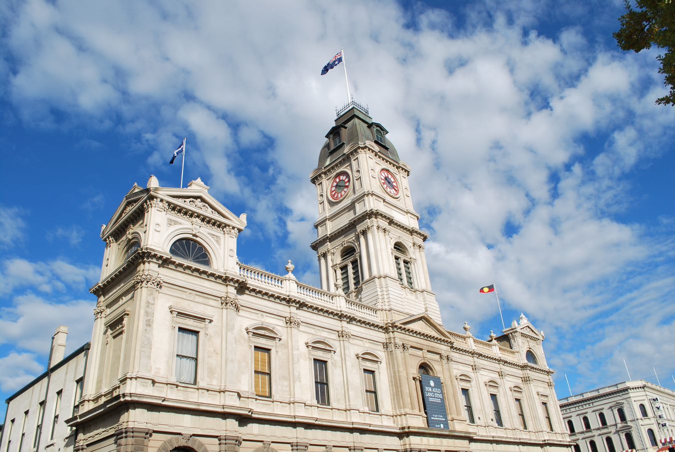 The image looks up at Ballarat Town Hall with a blue sky dotted with clouds in the background. 