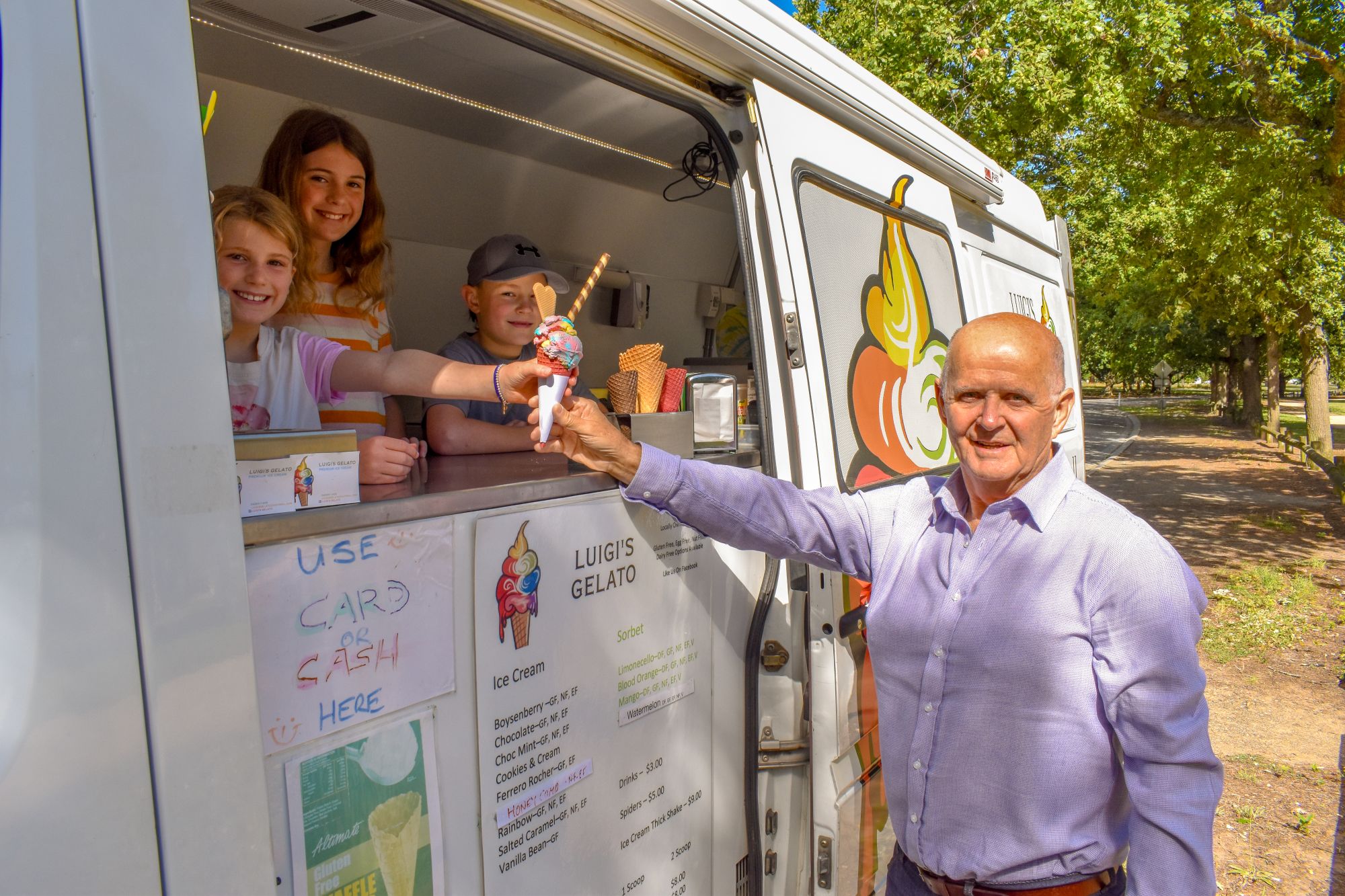 Cr Peter Eddy with children at Victoria Park receiving an ice cream