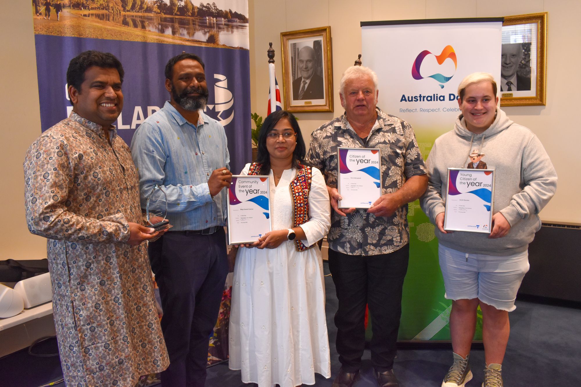 Five people holding their Community Awards up to the camera