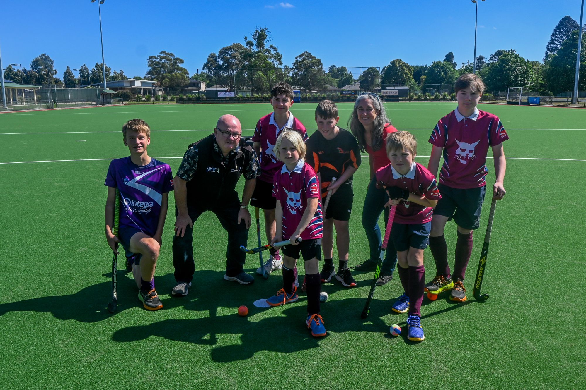 City of Ballarat Councillor, Cr Des Hudson with Hockey Ballarat president Jo Shepherd and junior hockey players on the new synthetic pitch at Prince of Wales Park.