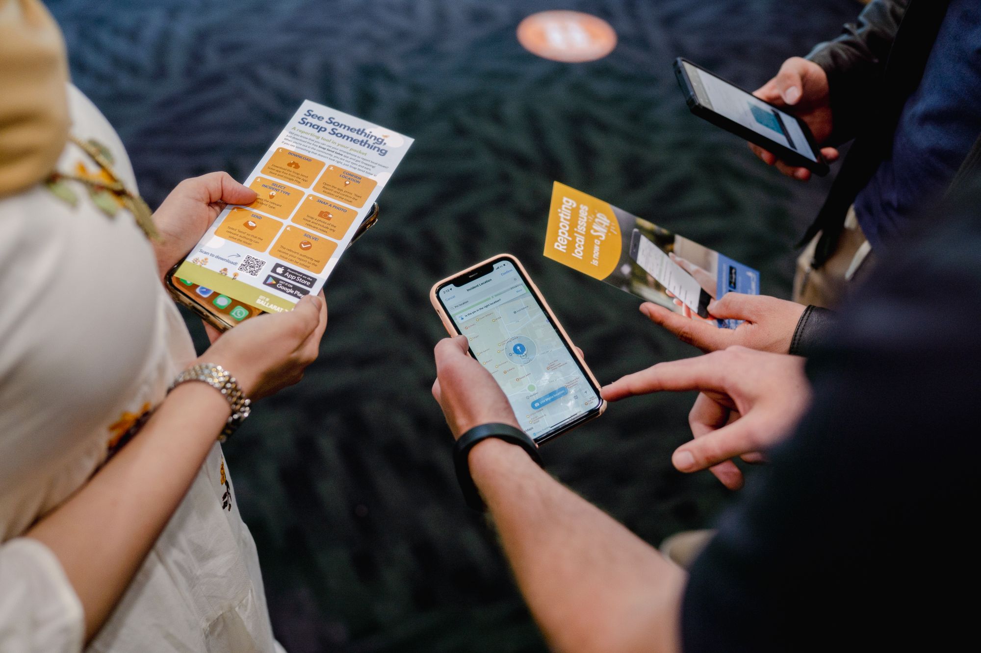 Generic image of people holding information pamphlets and mobile phones