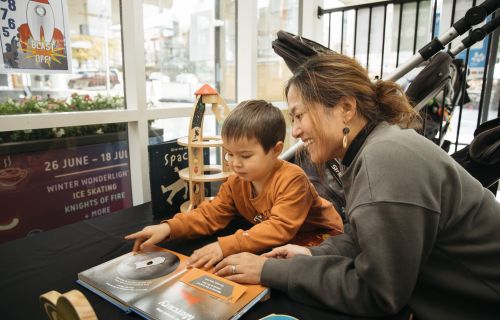 A woman reading a book with a young child
