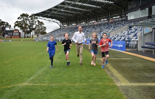 Generic photo children running with Steve Moneghetti at Mars Stadium