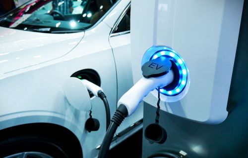 An electric vehicle is plugged into an electric vehicle charging station. 