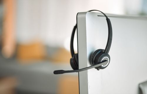 image of headset hanging over a computer screen