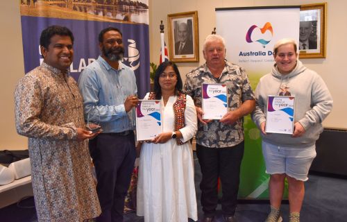 Five people holding their Community Awards up to the camera