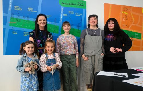 Two adults and three children stand in front of a blue map of Ballarat's CBD. 