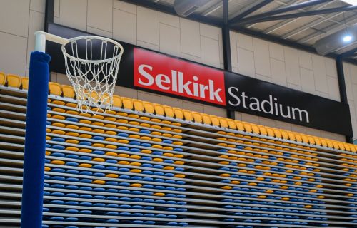 Sign of Selkirk Stadium with netball ring and seating