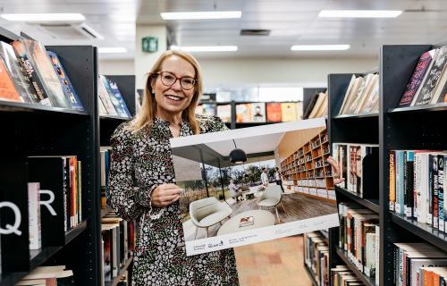 woman holding artist's impression of new library