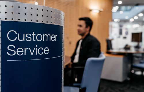 customer service sign with person sitting in the background