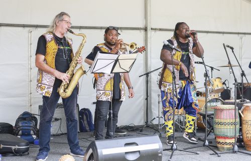 thre multicultural brass band members on stage performing at last years harmony fest
