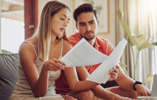 couple looking at paperwork looking worried