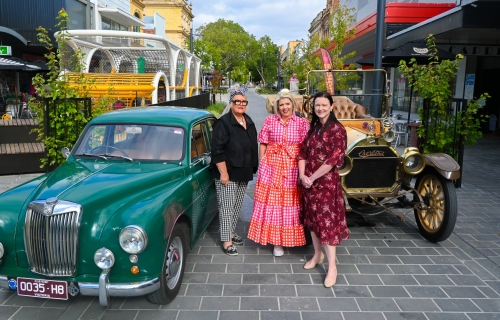 Image of the Bridge Mall with two vintage cars, two shop owners and the Mayor of Ballarat