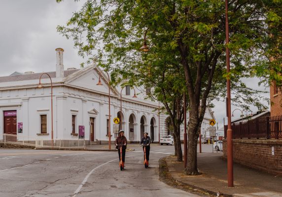 Generic image of two people using e-scooters Ballarat Train Station