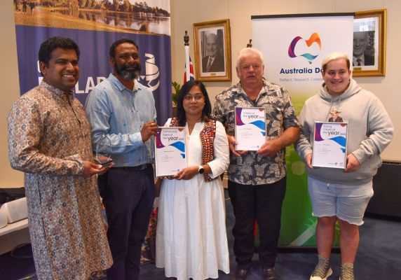 Five people holding their Community Awards up to the camera