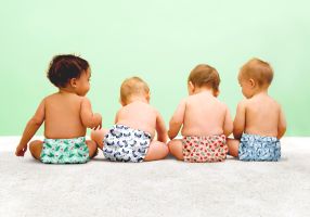 four babies wearing reusable modern cloth nappies
