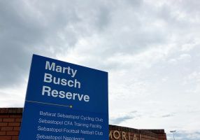 Blue Marty Busch signage with sky in background 