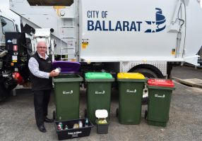 Mayor Des Hudson with four bins in front of a rubbish truck