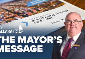 Text with The Mayor's Message with an image of Mayor Cr Des Hudson in front of the Public Housing Strategy