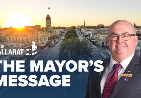 Text with The Mayor's Message with an image of Mayor Cr Des Hudson in front of an image of Ballarat