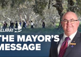 Text with The Mayor's Message with an image of Mayor Cr Des Hudson in front of a wide shot of a group of Nature Stewards walking through the bush.